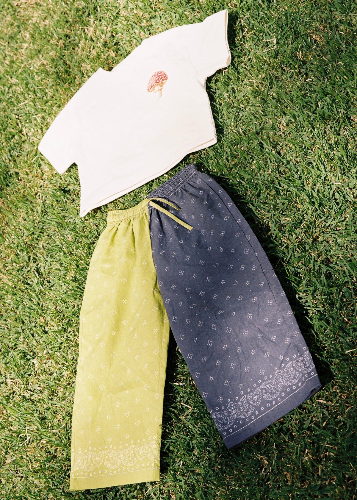 SOZO LAND Play Pant in Lime / Navy, featuring original Star Paisley print, contrasting two-tone colour blocking, wide legs and a soft elastic waistband, photographed flat on green grass.