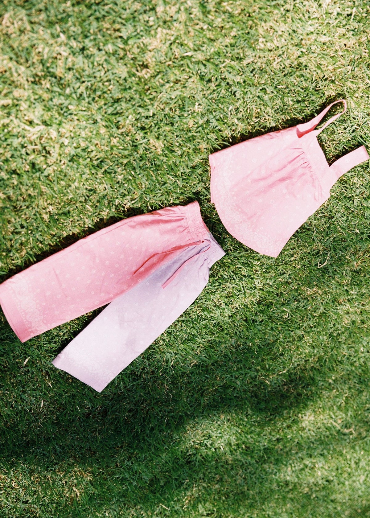 SOZO LAND Play Pant in Bubblegum / Lilac, featuring original Star Paisley print, contrasting two-tone pink and lilac colour blocking, wide legs and a soft elastic waistband, photographed flat on green grass.
